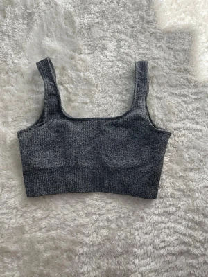 Grå ribbad sport-bh aimn - Materialet är stretchigt och mjukt, perfekt för en bekväm känsla. Diskret logga baktill. Passar perfekt till både träning och chill.