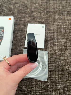 Xiaomi Smart Band 10 pulsmätare svart - Snygg och smidig Xiaomi Smart Band 10 med svart silikonarmband och avlång färgskärm. Perfekt för att hålla koll på puls, träning och hälsa. Laddkabel och manual medföljer i originalförpackning.
