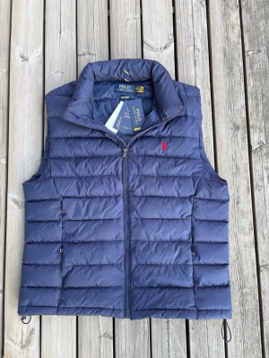 Ralph Lauren väst  - Helt ny Ralph Lauren väst med tags på. Storlek L, fin blå färg. Passar till det mesta och perfekt inför kommande säsonger! Orderbekräftelse finns! Hör av er vid eventuella frågor! 