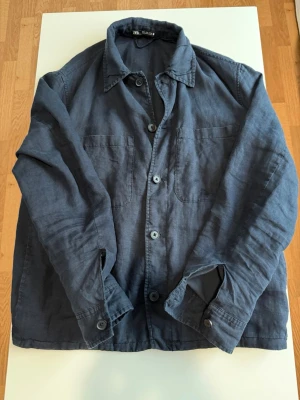 Mörkblå Overshirt  - Overshirt från Zara i mörkblått linne med klassisk krage. Skjortan har långa ärmar med knapp vid manschetten och en avslappnad passform. Perfekt för lager på lager och enkel att styla.
