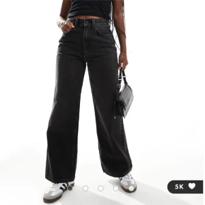 Svarta vida dad jeans från ASOS  - Säljer ett par svarta, vida dad jeans från ASOS Designs med hög midja och raka ben. Jeansen har klassisk femficksmodell och är tillverkade i kraftig denim. Perfekta för en avslappnad och trendig look.