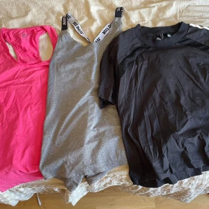Träningslinne och t-shirt i olika färger - Säljer ett rosa träningslinne , ett grått linne med svarta och vita axelband från Nike samt en svart t-shirt från adidas med meshdetaljer. Perfekta för gymmet eller löpning, alla i lätt och funktionellt material. 
