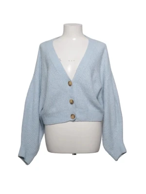 Ljusblå kofta från H&M Divided - Mysig ljusblå stickad kofta från H&M Divided med tre träfärgade knappar framtill. Koftan har v-ringning, ribbstickat mönster och är lite croppad i modellen. Perfekt att slänga på sig över en t-shirt eller linne.