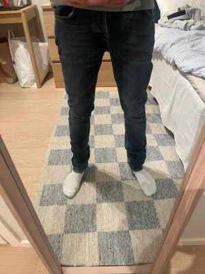 Blåa Nudie Jeans  - Snygga blåa slim fit jeans från Nudie jeans med oranga detaljer och vit fade. Normal midja och patch med logga bak i midjan. Tillverkade i denim av bomull. Perfekta för sommaren,  Hör av er vid frågor!😁