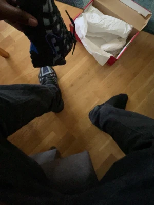 Svarta och blå sneakers från Salomon - Säljer ett par svarta och blå sneakers från Salomon med coola detaljer och snörning. Skorna har en sportig design med inslag av grått och blått, perfekt för dig som gillar streetwear och vill ha något bekvämt och snyggt till vardags.