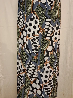 Läcker Mönstrad långkjol från elle - Säljer en långkjol från elle med ett unikt mönster som kombinerar prickar, gröna och blå detaljer samt inslag av orange. Kjolen har en flowy passform och är tillverkad i ett lätt syntetmaterial som känns skönt mot huden. Perfekt för dig som gillar att sticka ut med färg och mönster.
