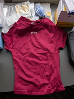 DFYNE set - Säljer en mörkröd tränings-tshirt, top och shorts från DFYNE. Materialet är lätt och andas, perfekt för gymmet eller löpning. Diskret logga på bröstet. Snygg passform och stilren design.