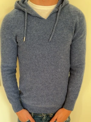 Blå hoodie i mjuk ullmix - Tja! Säljer nu dena feta merinoull hoodien som tyvärr blivit för liten för mig, den har ett par skavanker därav hål i armen men annars är den sjukt skön, bara att höra av er vid frågor🤝