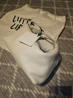 Little Liffner Pouch Bag - Little Liffner Pouch Bag, vitt mjukt, strukturerat läder. Unik, puffig form med ett kort handtag. Ny med prislapp. Dustbag medföljer.