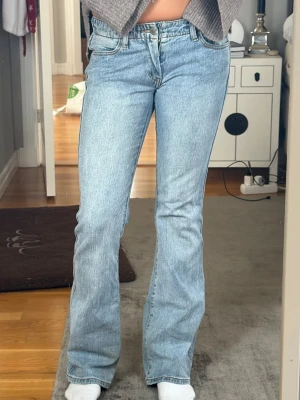 Ljusblå bootcut jeans - Säljer ett par Lågmidjade ljusblå bootcut jeans från märket brandy mellville . Jeansen har en snygg tvätt och är tillverkade i denim med lite stretch för skön passform. Jeansen är i storlek s, midjemått rakt över är ungefär 38 cm och innerbenslängden är 79cm. Byxorna är i mycket bra skick, nästan aldrig använda men har lite slitningar längst ner på båda benen (se bild).