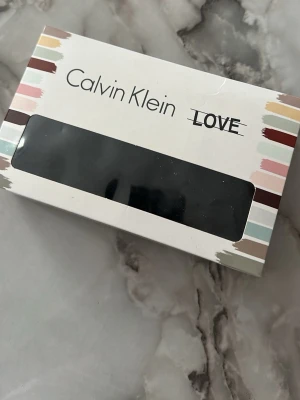 Svarta trosor från Calvin Klein - Säljer ett set med svarta trosor från Calvin Klein. Trosorna har bred resår med logotyp, och olika detaljer som prickar och blommönster. Materialet är mjukt och stretchigt, perfekt för dig som vill ha både stil och komfort.