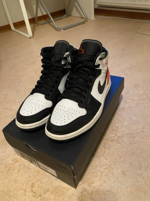 Nike Air Jordan 1 Mid svart/vit/röd - Säljer mina  Jordan 1, Materialet är en mix av läder och mocka. Har använt dem ett fåtal gånger och de är väl omhändertagna. Storlek 41!