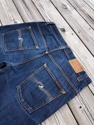 Mörkblå jeans från Nudie Jeans - Ett par riktigt snygga Nudie Jeans med en perfekt tvätt! Modellen är Thinn Finn. De är oanvända och helt utan defekter! Perfekta till sommaren!☀️ Köp innan någon annan gör! Kom gärna med bud eller frågor😁🙌   Mått efter utefter sista bilden:  Ben längd: 101 Innerbenssöm: 75 Midja: 40