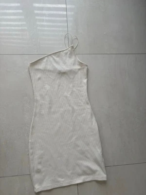 Vit oneshoulder ribbad klänning - Vanlig vit klänning med oneshoulder. Simpel lätt och är inte jobbig att ha på. 
