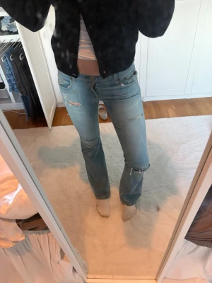 Ljusblå slitna bootcut jeans polo jeans  - Säljer ett par ljusblå bootcut jeans med slitningar och hål från början från polo jeans (Ralph lauren)  Jeansen är lågmidjade och köpta på Vinted för ca ett halvår sedan. Dom är i storlek 2 men i vanliga storlekar passar dom XS/34