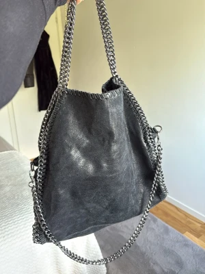 Svart handväska med kedjedetaljer - Snygg väska med 3 band