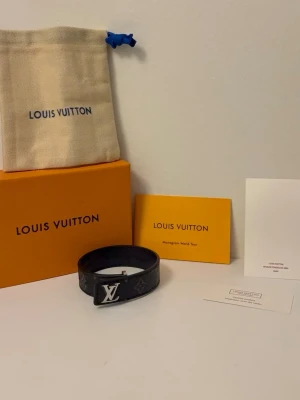 Svart armband - Snyggt svart bälte från  med klassiskt mönster och silverfärgat spänne. Bältet är gjort i skinn och har en stilren design som passar till många outfits. Kommer med originalförpackning och dustbag.