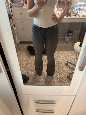 Grå bootcut jeans från Vero Moda - Säljer ett par grå midwaist bootcut jeans. Jeansen har en snygg tvättad look och raka ben som går ut lite nedtill. Perfekta till en avslappnad stil och passar till det mesta. De är knappt använda och är jättefina på!❤️