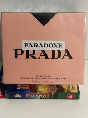 Prada Paradoxe Eau de Parfum 90ml - Prada Paradoxe Eau de Parfum i en snygg rosa förpackning med svarta detaljer. Flaskan rymmer 90 ml och är en påfyllningsbar spray. Perfekt för dig som gillar exklusiva och moderna dofter från ett lyxigt märke.