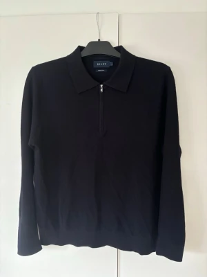 Superfin Riley Half zip M - Superfin snygg elegant och eftertraktad svart Eiley half zip i nyskick och storlek M. Superfin på grym passform perfekt för alla tillfällen!