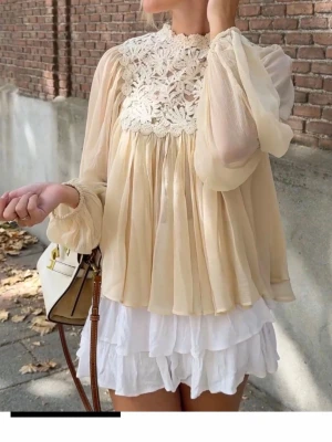Beige blus med spets NMP - Romantisk beige blus med långärmade, vida ärmar och vacker spets upptill. Ny med prislapp. Nypris 799kr