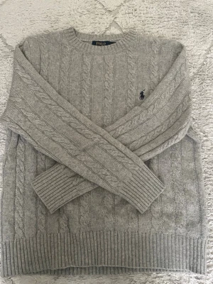 Polo Ralph Lauren stickad hoodie - Grå Polo Ralph Lauren stickad hoodie med stilren och klassisk design. Mjuk, bekväm och perfekt för både vardag och en clean outfit. Bra skick. Pris kan diskuteras vid snabb affär.