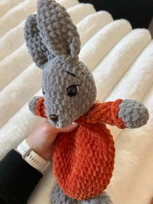 Grå kanin med orange klädsel snuggle - Detta säljer jag åt min kompis som har virkat denna fina fina gråa kanin med orange klädsel, huvudet, armarna och fötterna är stoppade men inte magen så det blir en snuggle😊🫶🏼