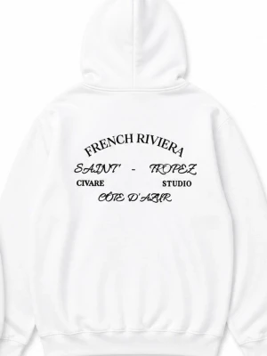 Vit hoodie från Civare Studio - Snygg vit hoodie från Civare Studio med tryck på ryggen där det står 'French Riviera', 'Saint-Tropez', 'Côte d'Azur' och liten logga fram. Klassisk passform med huva och känguruficka. Perfekt för en clean och stilren look.