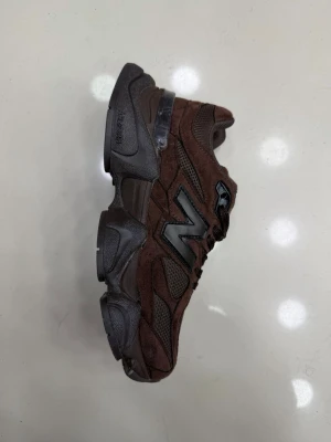 Bruna New Balance 9060 sneakers (finns i storlek 37-40) - Snygga New Balance 9060 sneakers i brunt mocka och mesh med grå detaljer och robust sula. Ikoniska N-loggan på sidan och klassisk snörning. Perfekta för dig som gillar streetwear och vill sticka ut med en chunky siluett.