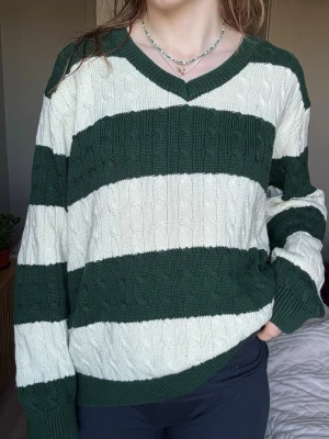 Randig stickad tröja- BRANDY MELVILLE - Stickad tröja med breda gröna och vita ränder från Brandy Melville. One-size med passform i ”Loose fit”, bekväm och stilren.