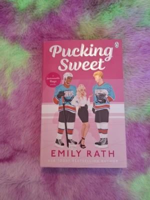 Pucking Sweet - Emily Rath - 🩷Säljer Pucking Sweet - Emily Rath. Tredje boken I serien Jacksonville Rays.  🩷Helt oläst, endast stått i bokhyllan.   📦 Skickas snabbt 💬 Hör av dig om du har frågor!