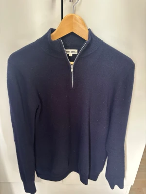 Soft Goat mörkblå  - Mörkblå 100% Kashmir tröja från Soft Goat med halv dragkedj. Tröjan är långärmad och har en klassisk, stilren design. Har ett litet hål vid armhålan som lätt går att lösa, men sänker därav priset. Nypris: 2995kr
