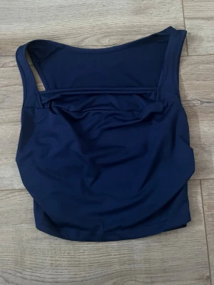 Mörkblå topp - Snygg mörkblå topp med breda axelband och rundad halsringning. Klassisk och stilren design perfekt till fest eller festlig vardag 