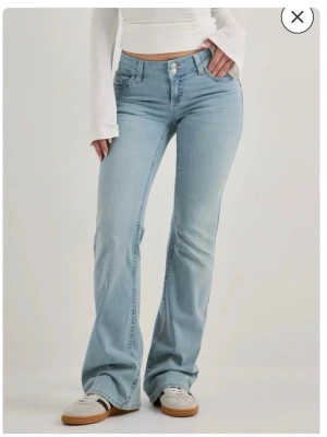 Ljusblå bootcut jeans från nelly - Säljer ett par ljusblå bootcut jeans med snygg rosa zigzag-brodyr på bakfickorna. Jeansen har klassisk femficksmodell, låg midja och är tillverkade i mjuk denim. Används tyvärr för lite.