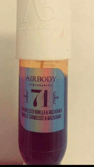 Airbody 71 Caramelized Vanilla & Macadamia - En parfym från Airbody med doft av karamelliserad vanilj och macadamia. Flaskan är cylinderformad med vit kork och etikett i blått och svart. Perfekt för dig som gillar söta och nötiga dofter.
