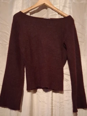 Mörkbrun stickad tröja Gina Tricot - Mysig mörkbrun stickad tröja från Gina Tricot med bred båturringning och långa ärmar. Tröjan har en enkel, rak passform och är perfekt för lager på lager. Materialet känns mjukt och passar bra till höst och vinter.