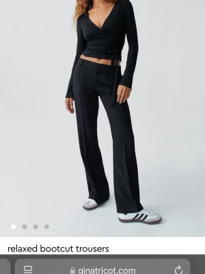 Svarta bootcut kostymbyxor Gina Tricot - Snygga svarta kostymbyxor från Gina Tricot med relaxed passform och bootcut-ben. Byxorna har hög midja, pressveck och klassiska fickor fram. Perfekta för en trendig och avslappnad look.