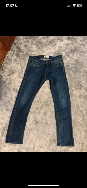 Mörkblå jeans från Replay - Snygga mörkblå jeans från Replay med klassisk femficksdesign och kontrastsömmar. Jeansen har raka ben och detaljerade bakfickor med Replay-logga på läderpatch. Tillverkade i mjuk denim med lite stretch för skön passform.