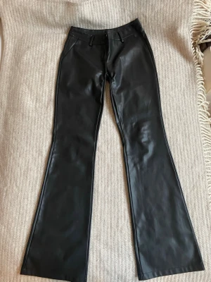Svarta Lågmidjade skinnbyxor - Säljer ett par Lågmidjade skinnbyxor!! Utsvängda! Dem är sydda lowwaist( så bra kunde)Skriv om fler bilder💞💞 märket är Design By Si men köpte dem här på Plick!! 