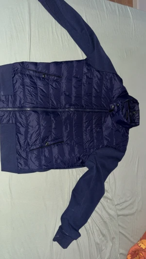 Mörkblå pufferjacka Polo Ralph Lauren [VINTED] - Säljer en mörkblå pufferjacka från Polo Ralph Lauren i storlek L. Jackan har quiltad framsida, dragkedja, två fickor med knappstängning och mjuka ärmar i bomullsmix. Perfekt för kylan och för en nice look! 👀