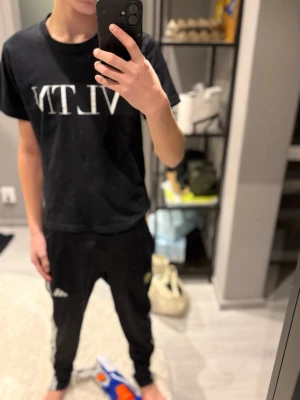 Svart VLTN t-shirt från Valentino - Snygg svart t-shirt från Valentino med VLTN-tryck i vitt framtill. Klassisk rund hals och korta ärmar. Tillverkad i mjuk bomull som känns skön mot huden. Perfekt för dig som gillar stilrena och trendiga plagg med exklusiv känsla.