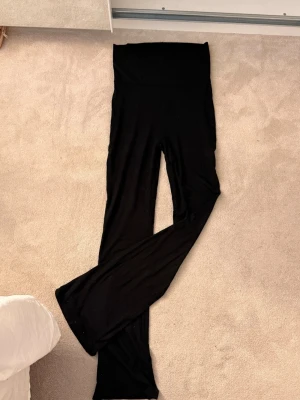 Svarta yoga pants  - Säljer ett par svarta yoga pants med bootcut-modell och hög midja. De är mjuka och stretchiga, perfekta för en avslappnad och trendig look. Materialet känns som bomullsmix och de har en bred linning upptill för extra komfort. Lappen är bortdragen men annars superbra skick💖