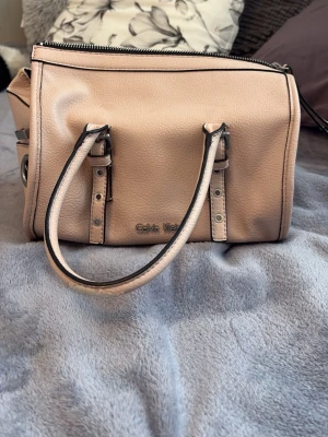 Rosa handväska💘 - Snygg rosa handväska  i mjukt, strukturerat skinn. Väskan har två rejäla handtag med silverfärgade spännen och detaljer, samt dragkedja upptill. Perfekt storlek för det viktigaste och stilren design med diskret logga framtill. Jättesöt väska💞 skriv om frågor 😋🫶🏼