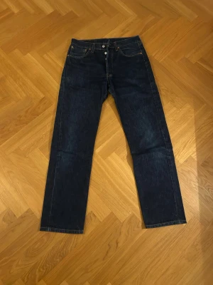 Blå Levi's jeans i modell 501 - Snygga Levis jeans i modell 501 storlek 32 längd 32!🔥Jeansen är i mörkblå och har använts ett fåtal gånger!🙌Pris kan diskuteras. Hör gärna av er vid frågor eller mått!😎🧊