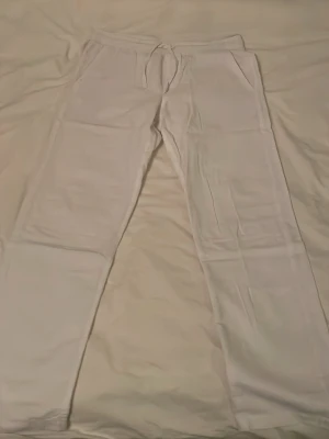 Vita linnebyxor från Jack & Jones - Säljer ett par vita linnebyxor från Jack & Jones. Byxorna har dragsko i midjan, resår och två sidofickor. Tillverkade i mjukt material som passar perfekt för chill dagar. Klassisk rak passform och enkel stil.