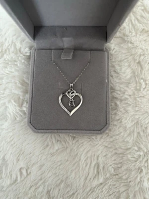 Silverhalsband med hjärthänge och bokstav”går att ta bort” - Säljer mitt halsband som jag fick i present, ny pris 699, aldrig använt äkta silver rekommenderar 