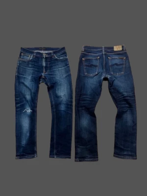 Dry Lean dean Nudie Jeans  - Riktigt snygga Nudie jeans i dry denim|| byxorna har blivit lagade mellan bena av nudie || sen har fickorna fått slitningar.  storlek 31/32, men sitter  mindre. Så jämför med dessa                             Jeans mått:📐                                                                     Total längd: 92cm  Benöppning: 16cm.                                                       Lår: 27cm Midja:40cm
