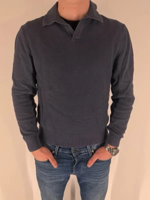 Mörkblå These Glory Days pikétröja  - Snygg mörkblå pikétröja med klassisk krage och lång ärm från Volts egna märke - These Glory Days. Tröjan har diskret struktur i tyget och ribbade muddar vid ärmslut och nederkant. Riktigt fin tröja, som tyvärr börjar bli för liten. Jag är 173cm och väger ca 63kg.  Perfekt för en stilren och avslappnad look.