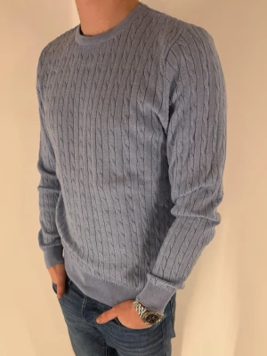 Stenströms kabelstickad tröja - Blå kabelstickad rundhalsad tröja från Stenströms. Väldigt fint skick, använd ca 3 gånger. Tröjan är i 100% merinoull. Storleken är medium, men sitter mer som small skulle jag säga. Jag är ca 173cm och väger 63kg.