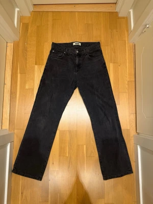 Svarta raka jeans Woodbird - Säljer ett par svarta jeans från Woodbird med rak passform och klassisk femficksdesign. Jeansen har knappgylf och är tillverkade i ett kraftigt bomullstyg. Perfekta för en avslappnad och stilren look. modellen heter WBWik crow och modellen är 185cm lång samt väger 82kg. Orginalpris 1000kr+